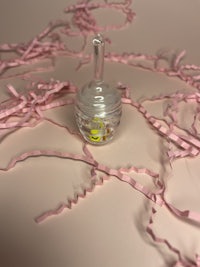 a small glass bottle surrounded by pink ribbons